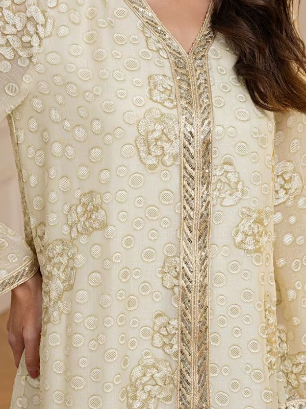 Zoom sur les broderies dorées et les détails du tissu de la djellaba