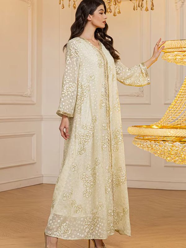 Femme de profil en djellaba longue brodée dans un décor raffiné