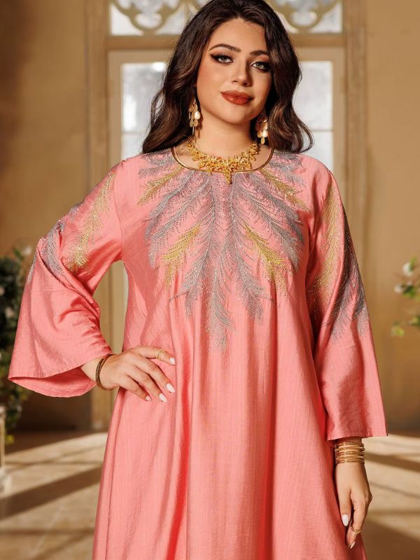 Une femme croise les mains et porte une djellaba rose