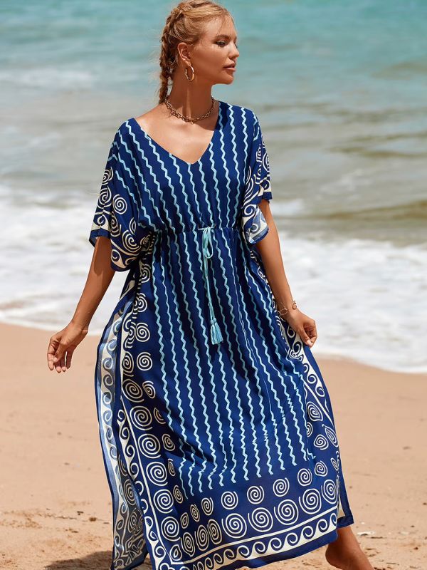 Une femme blonde qui porte une djellaba bleu à la plage 
