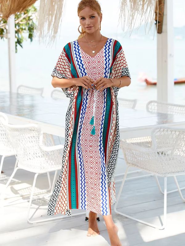 Une femme vêtue d’une djellaba traditionnelle à motifs andalous multicolores pose de face dans un espace lumineux