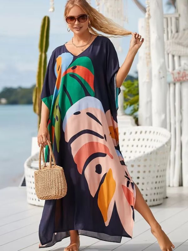 Une femme élégante porte une djellaba à imprimés exotiques et marche pieds nus sur une terrasse en bord de mer