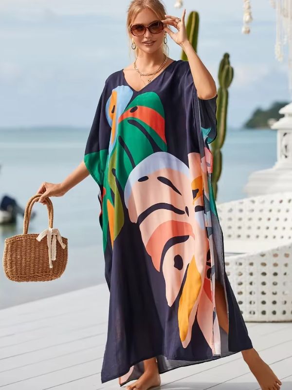 Une femme porte une djellaba aux tons vifs et tient un sac en osier tout en marchant sur une terrasse balnéaire