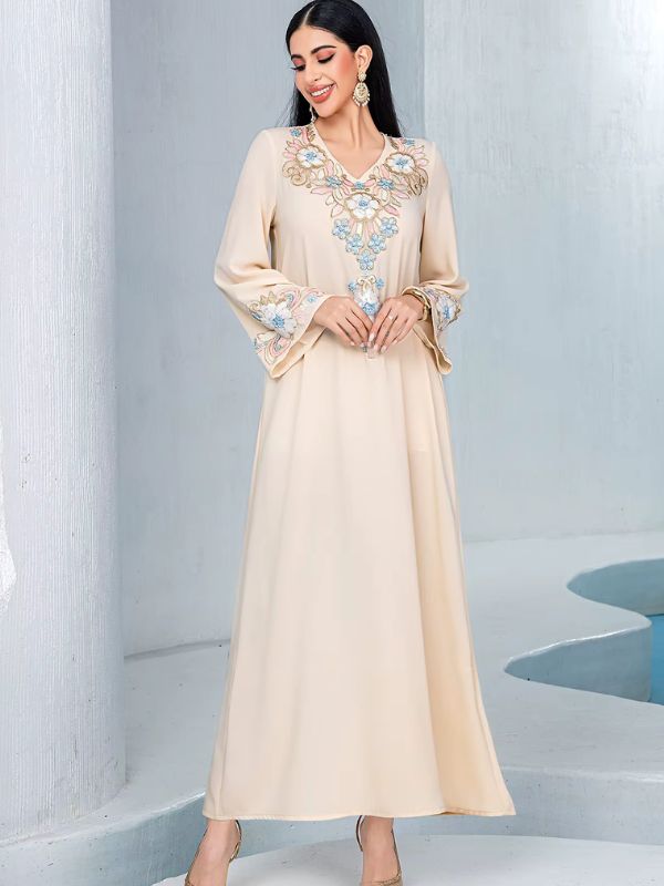 Djellaba marocaine beige, vue de face, mains jointes, broderie florale sur l'encolure et les poignets