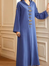 Femme qui porte une djellaba marocaine bleu ciel et qui se tient contre le mur