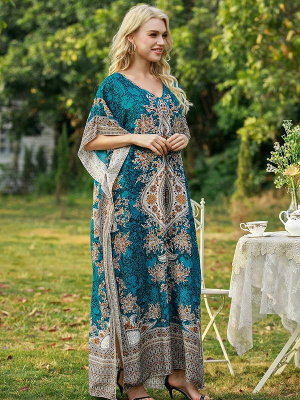 Une femme en djellaba marocaine verte élégante posant près d’une table de thé