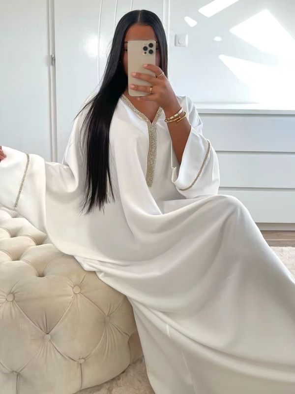 Une femme est assise en djellaba 