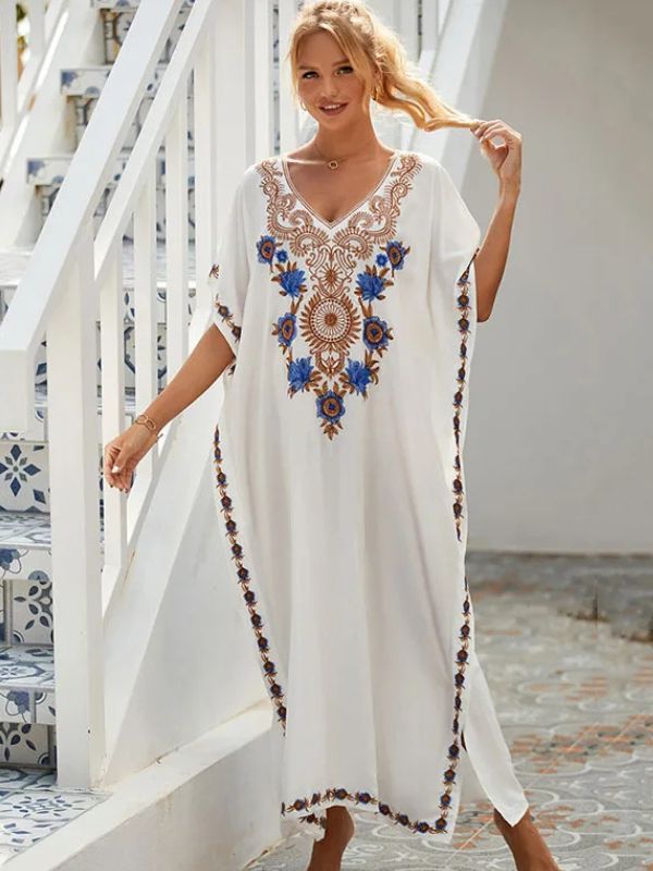 Femme souriante en djellaba blanche ornée de broderies dorées, posant sur un yatch