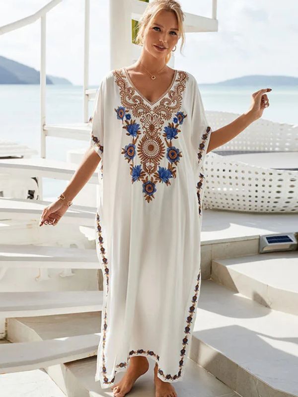 Femme souriante en djellaba blanche ornée de broderies dorées, posant sur un yatch