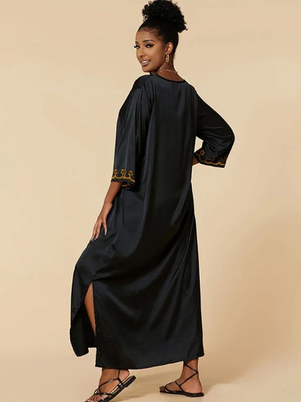 Femme de dos en djellaba noire satinée à manches brodées dorées, regard par-dessus l’épaule