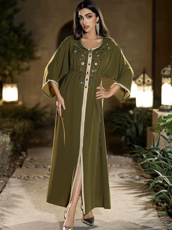 Femme en djellaba verte fendue devant, ambiance nocturne aux lanternes