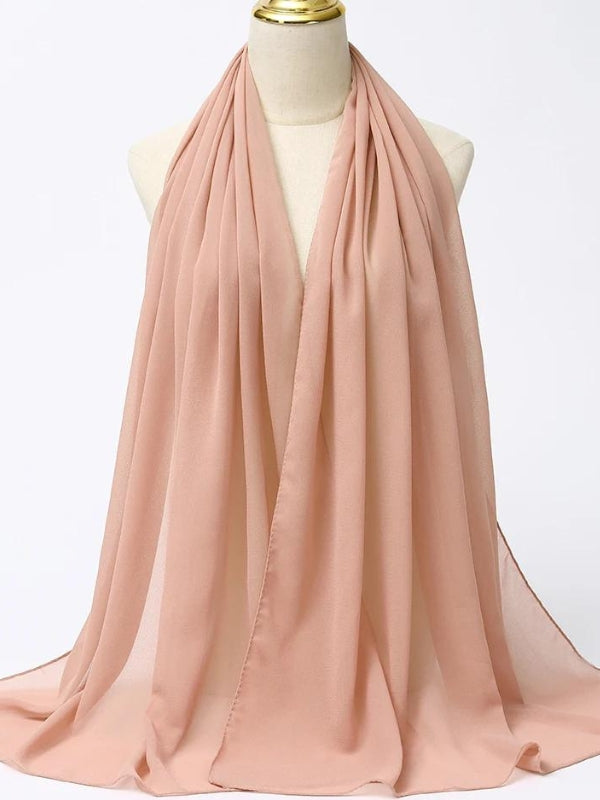 Ce hijab beige rosé, soigneusement drapé sur un mannequin, se distingue par son tissu léger et aérien. Sa couleur douce et neutre le rend polyvalent, facile à assortir avec différentes tenues, qu'elles soient décontractées ou habillées. La matière semble fluide, créant de délicates ondulations qui ajoutent de la texture et du mouvement. Idéal pour un look épuré et élégant, ce hijab beige est parfait pour celles qui recherchent un accessoire discret mais chic