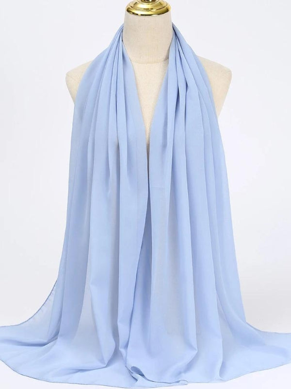 Le hijab de couleur bleu ciel est drapé élégamment sur un mannequin. Son tissu semble léger et fluide, ce qui lui donne une allure douce et aérienne. Ce voile apporte une touche de fraîcheur et de simplicité, parfait pour un style sobre et élégant