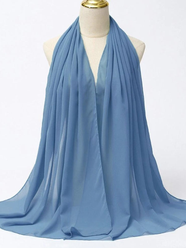 Ce hijab bleu est présenté sur un mannequin, révélant sa texture fluide et légère. La couleur bleu douce offre une touche de neutralité élégante, parfaite pour s'assortir avec une variété de tenues. Le tissu semble être de haute qualité, avec un drapé fluide qui ajoute du mouvement et de la grâce à l'ensemble. Ce hijab est idéal pour celles qui recherchent un look simple