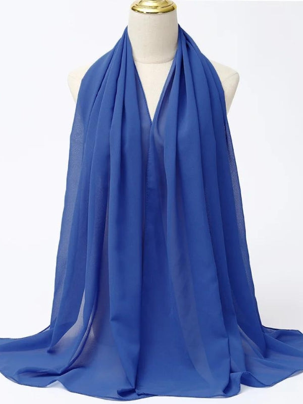 Ce hijab bleu vif est exposé sur un mannequin, mettant en évidence la légèreté et la transparence du tissu. La couleur éclatante offre un contraste saisissant, parfait pour illuminer n'importe quelle tenue. Les plis doux ajoutent de la profondeur et de la texture, faisant de ce hijab un choix idéal pour une touche de couleur rafraîchissante