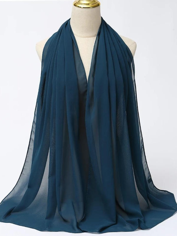 Ce hijab en bleu foncé est drapé avec élégance sur un mannequin, mettant en valeur la fluidité de son tissu léger. La couleur profonde ajoute une touche de sophistication et de calme, parfaite pour une tenue formelle ou pour apporter une dimension subtile à une tenue plus décontractée. Les plis naturels créés par le tissu ajoutent de la texture et du mouvement, faisant de ce hijab un choix polyvalent pour diverses occasions