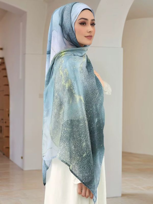 Hijab en coton imprimé bleu lagon, porté de profil, dégradé marbré du bleu clair au bleu-vert profond, veines vert anis