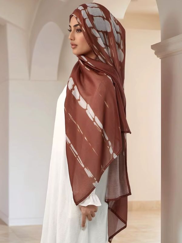 Hijab en coton imprimé brun châtaigne, porté de profil, bandes tie-dye ivoire sur fond brun rouille, liseré foncé