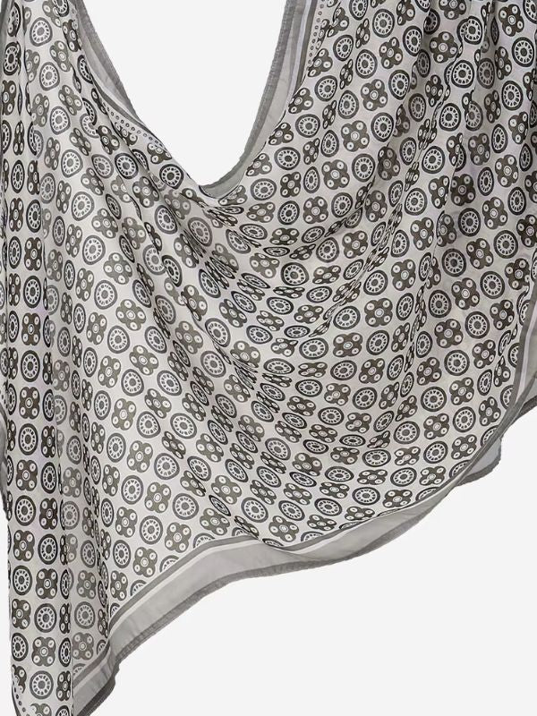 Hijab en coton imprimé gris à rosaces, drapé en plis, cercles concentriques taupe foncé et blancs sur fond gris clair, bordure grise