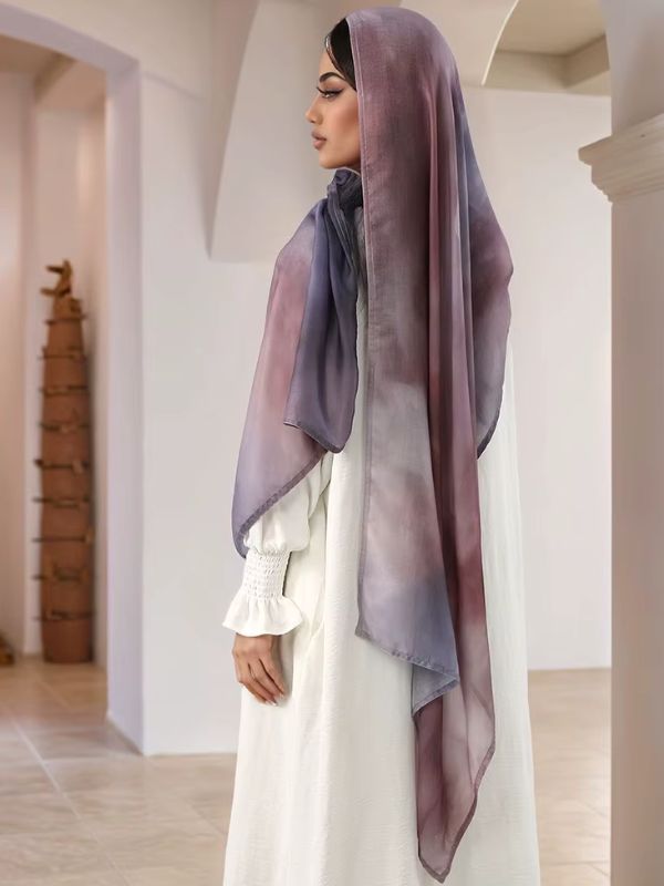 Hijab en coton imprimé mauve brume, porté de profil, dégradé fondu du gris-bleu au mauve et à la prune, long pan dans le dos