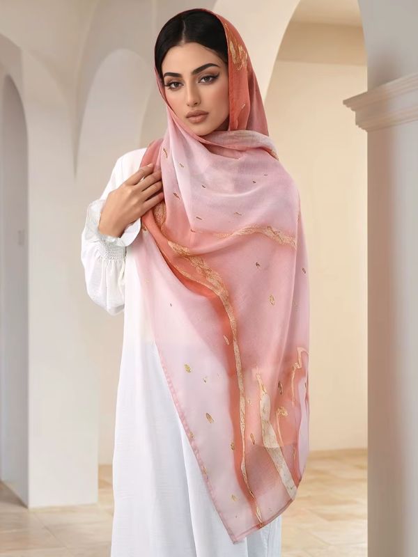 Hijab en coton imprimé rose corail, porté de face, dégradé du rose pâle au corail, touches et veines dorées