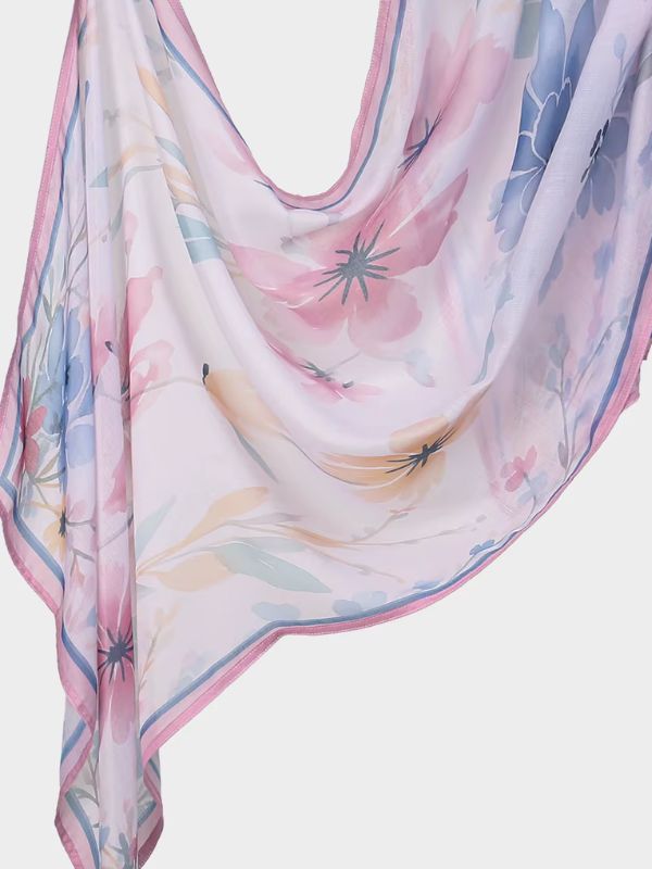 Hijab en coton imprimé rose à liseré bleu, drapé en plis, grandes fleurs à l'aquarelle roses, bleues et ocre, bordure rose