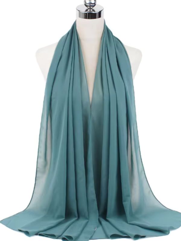 Hijab en mousseline bleu sarcelle soigneusement drapé sur un mannequin