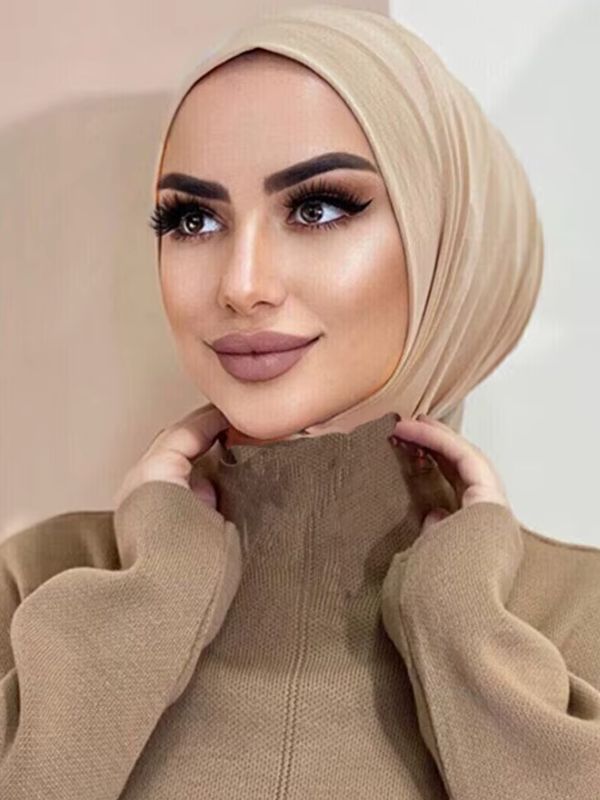 Hijab jersey premium instantané beige sable, porté, mains près du cou, voile ajusté en fins plis autour du visage