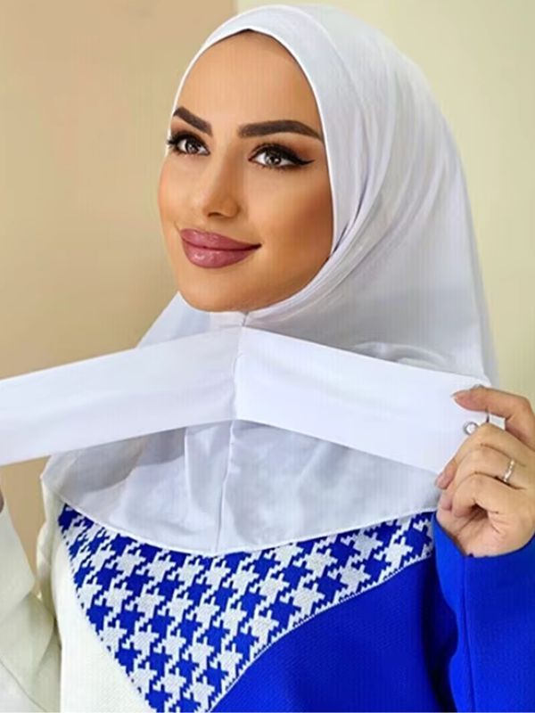 Hijab jersey premium instantané blanc, porté, bande croisée tenue à la main, bouton visible à son extrémité
