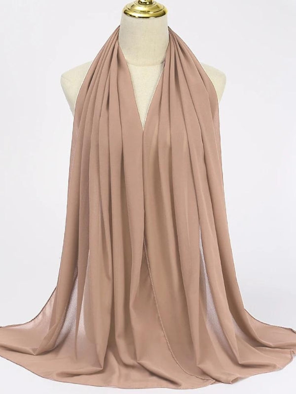 Un hijab en mousseline de couleur rose léger est exposé sur un mannequin. Le tissu léger et fluide tombe en plis gracieux, offrant un drapé naturel et élégant. Sa teinte beige clair est neutre et polyvalente, idéale pour s'harmoniser avec une variété de tenues. Ce hijab ajoute une touche de simplicité sophistiquée, tout en permettant une grande liberté de mouvement et de style, parfait pour une utilisation quotidienne ou pour des occasions spéciales