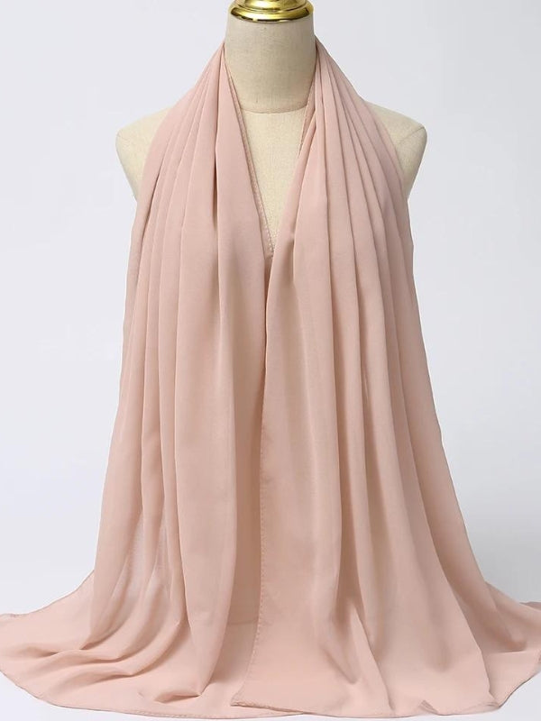 Un hijab en mousseline de couleur rose pâle est disposé sur un mannequin. Le tissu léger et transparent tombe délicatement, créant des plis fluides et élégants. La couleur rose pâle ajoute une touche de douceur et de féminité, idéale pour un look élégant et raffiné. Ce hijab, avec son drapé fluide, est parfait pour apporter une touche de sophistication subtile à n'importe quelle tenue, tout en offrant confort et style