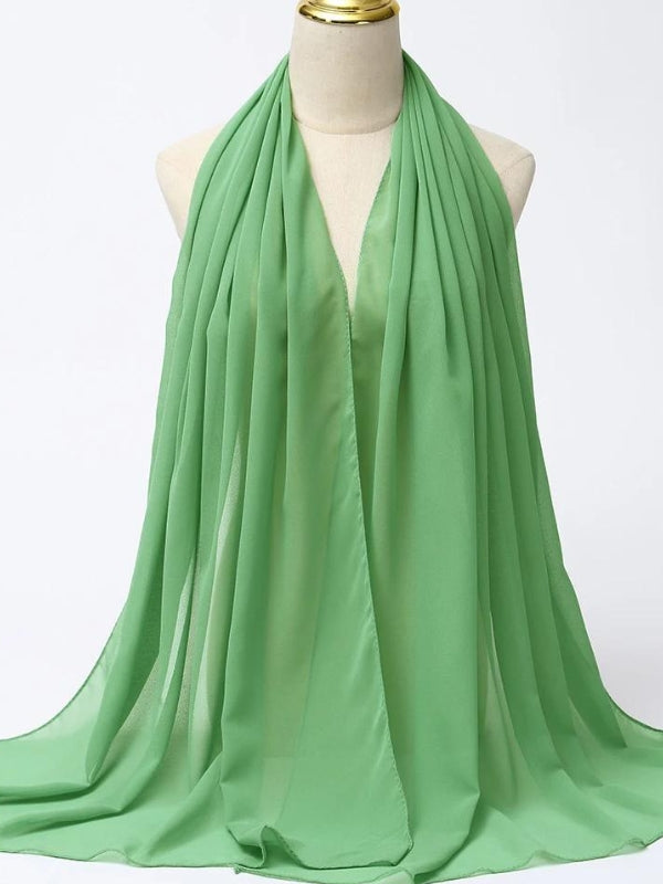 Ce hijab vert est drapé avec élégance sur un mannequin, mettant en valeur sa matière légère et fluide. La couleur vive et rafraîchissante de ce hijab ajoute une touche de fraîcheur et de vitalité, idéale pour les saisons printanières et estivales. La texture lisse du tissu permet une tombée fluide, créant un effet de douceur et de légèreté autour du visage. Ce hijab vert est parfait pour apporter une touche de couleur à une tenue tout en conservant une allure sophistiquée et raffinée