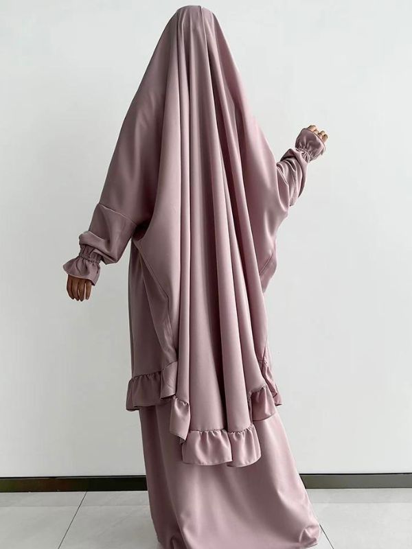 Vue de dos d'un jilbab deux pièces rose pâle avec des volants subtils sur l'ourlet