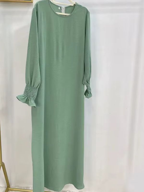 Robe longue vert sauge à poignets smockés présentée sur cintre, le khimar n'étant pas photographié