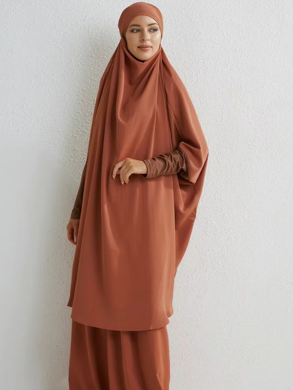 Femme debout portant un jilbab ample couleur caramel, avec une coupe fluide