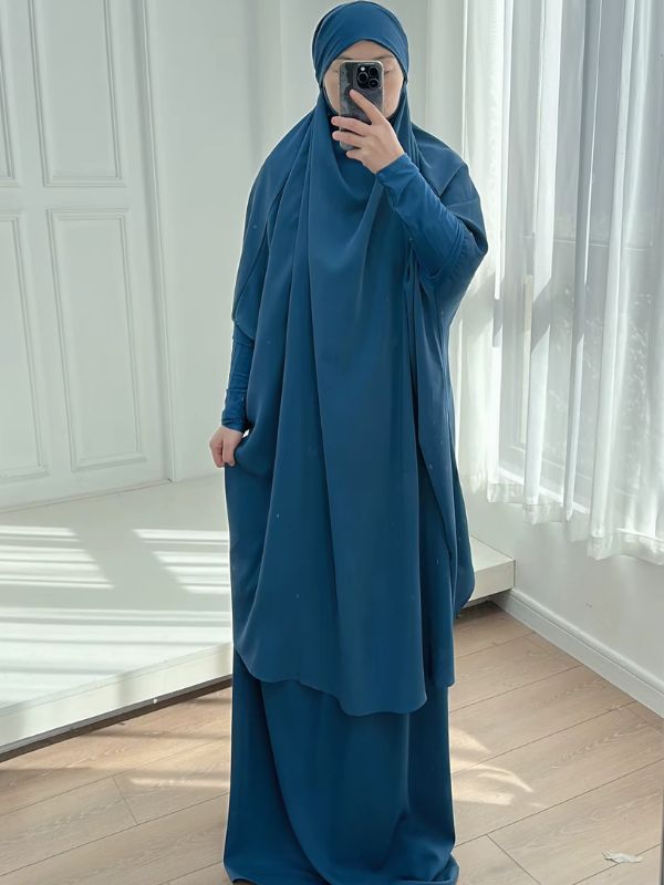 Jilbab femme deux pièces bleu pétrole, grand haut à capuche et jupe longue, vue de face, main sur la jupe