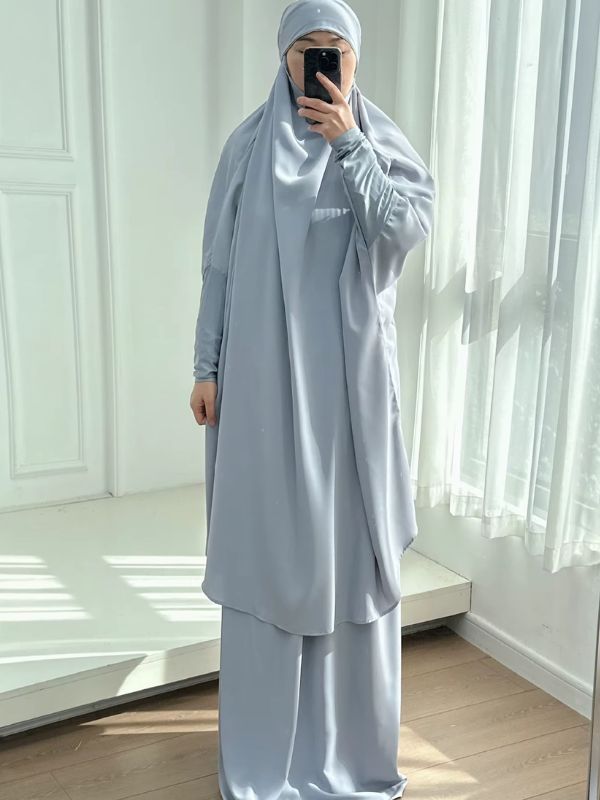 Jilbab femme deux pièces gris bleuté, grand haut à capuche et jupe longue, vue de face dans un espace lumineux