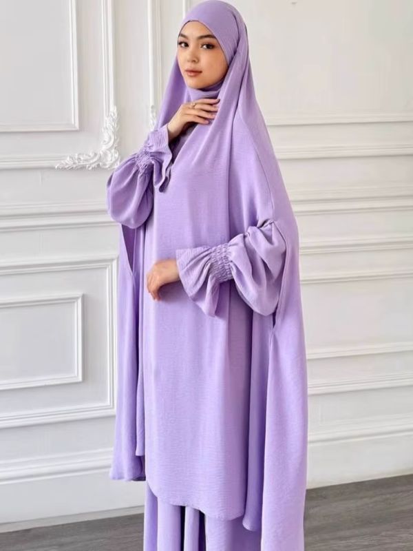 Jilbab femme deux pièces lilas, grand haut à capuche et jupe longue, vue de trois quarts, main posée près du menton
