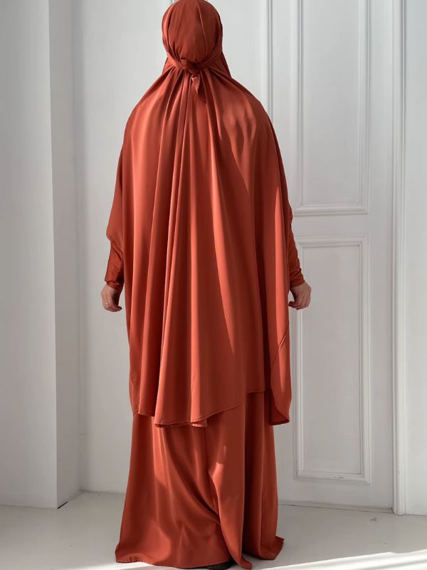 Dos du jilbab femme terracotta, grand haut à capuche noué à l'arrière de la tête, ourlet arrondi et jupe longue