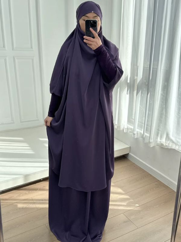 Jilbab femme deux pièces violet, grand haut à capuche ample et jupe longue, vue de face, main soulevant le haut