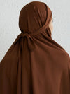 Vue de dos d&#39;une femme portant un jilbab long de couleur marron, avec le voile noué à l&#39;arrière