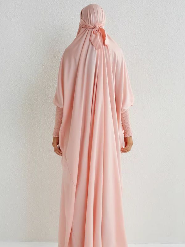 Femme de dos porte un jilbab rose