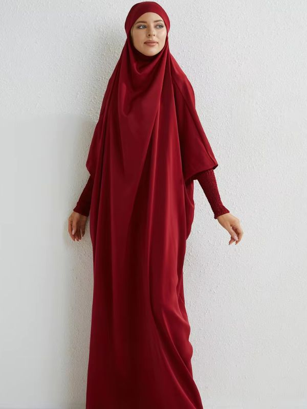 Femme portant un jilbab rouge ample, mettant en avant la coupe fluide