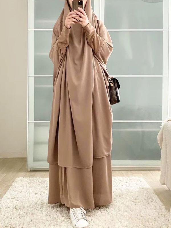 Une femme prend une photo miroir en portant un jilbab beige sable long