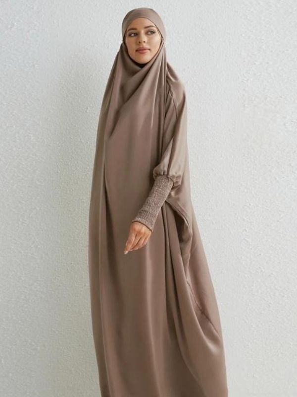 Une femme porte un magnifique jilbab de couleur taupe