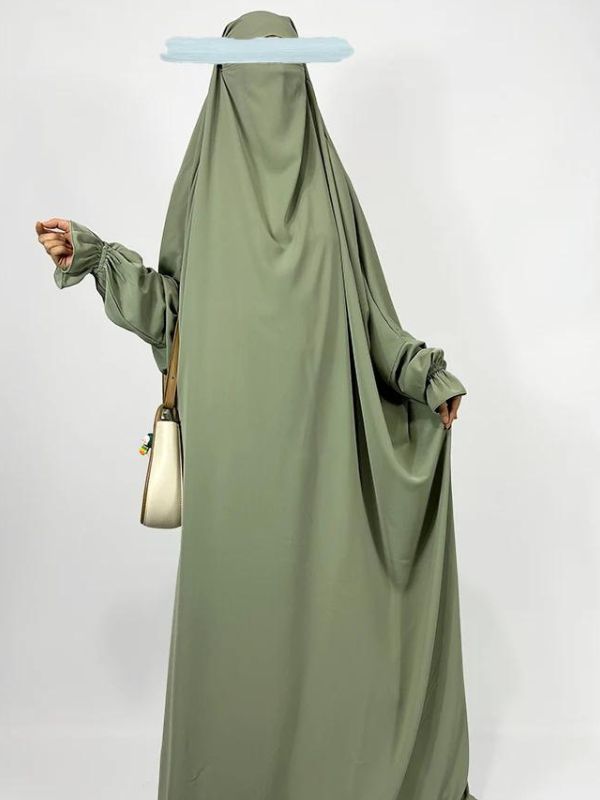 Une femme porte un long jilbab vert olive