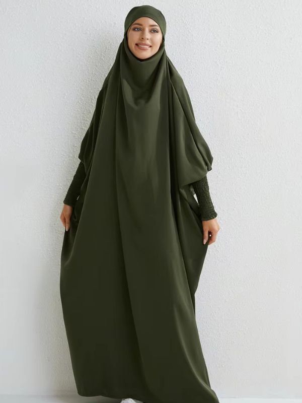 Femme souriante qui porte un jilbab vert