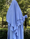 Khimar à trois voiles bleu ciel porté en extérieur, offrant une allure modeste