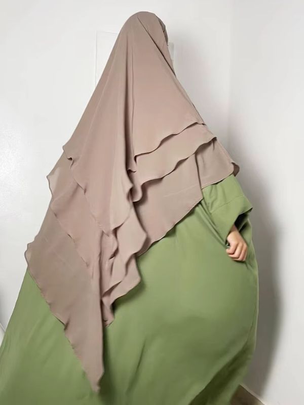 Une femme porte un khimar kaki plissé en mousseline