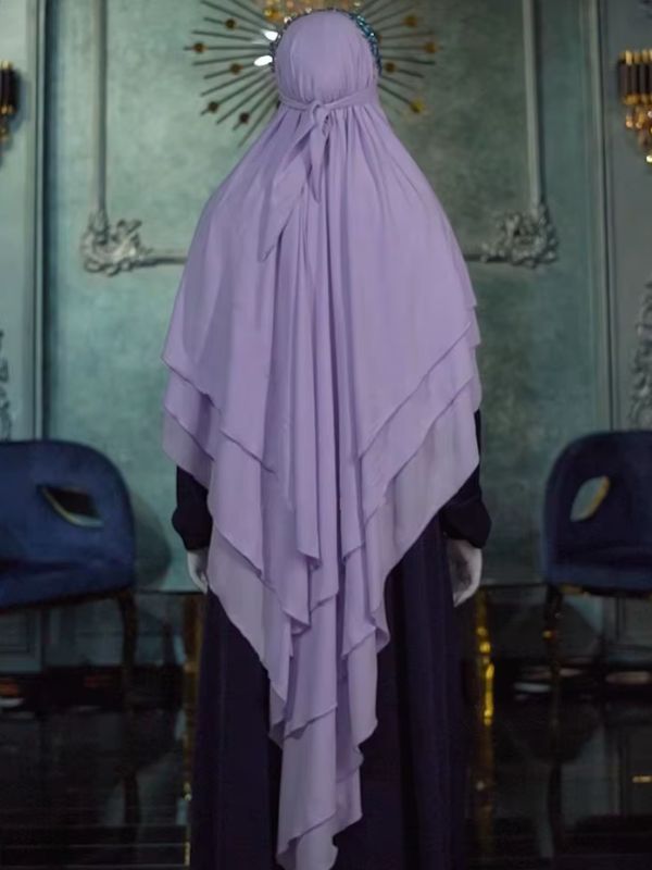 Une femme porte un khimar lavande noué à l'arrière